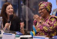 Two women sitting at a table share a laugh